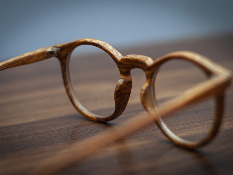 A pair of glasses sitting on top of a wooden table.